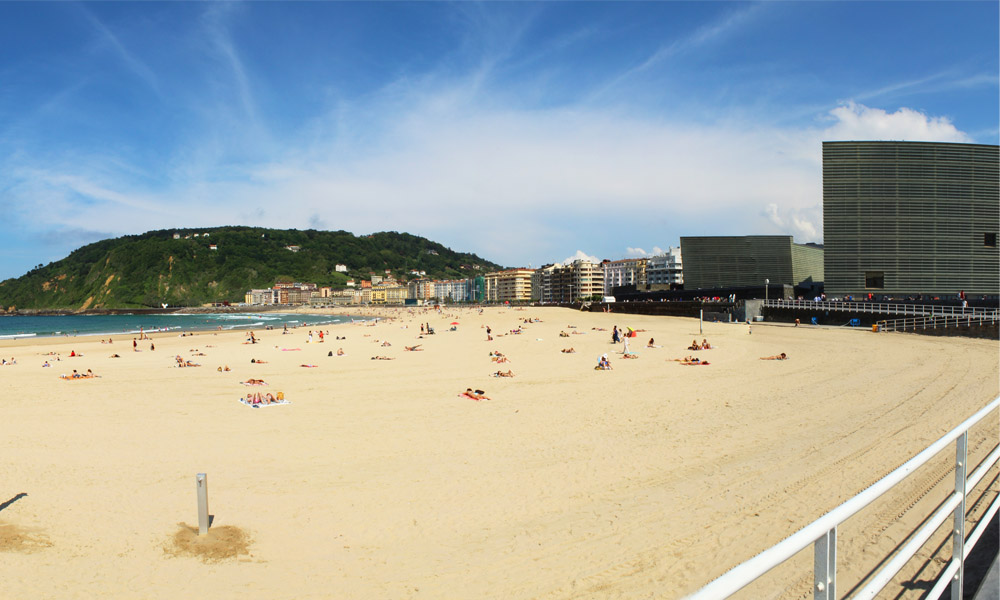 fotografia de la playa de la zurriola con una vista parcial del palacio congresos kursaal, en el barrio de gros